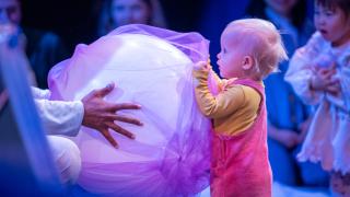 Lapsi kulttuuriesityksessä ison pallon kanssa.