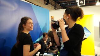 Varian opiskelija neuvoo messuvieraalle VR-lasien käyttöä