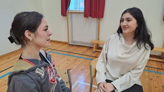 Nuorisovaltuutetut Sahar Hossaini ja Aisha Akaydin istuvat salissa keskustelemassa.