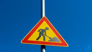 Työmaakyltti sinisellä taustalla.