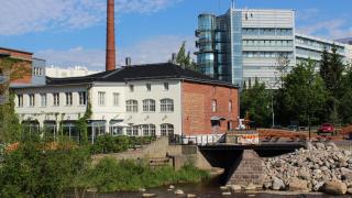 Kulttuuritehdas Vernissan rakennus, edessä virtaa joki. 