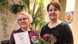 Sanna ja Sari Pörssitalolla. Sannalla on kädessään kunniakirja ja Sarilla kukkakimppu.