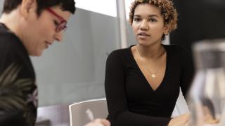 Kaksi asiantuntijaa neuvottelupöydän ääressä.