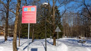 Punainen kyltti on puiston reunassa. 