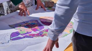 Ihmisiä tutkimassa kaavakarttaa.