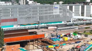 Ilmakuvassa näkyy työmaan kaivanto raiteiden alla.