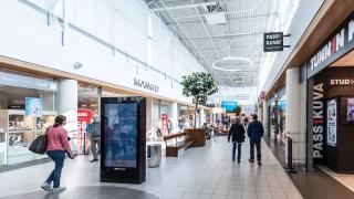 Ihmiset kävelevät valoisassa kauppakeskuksessa.