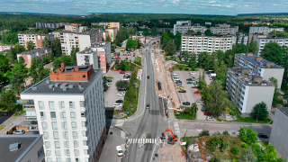 Ilmakuvassa Hakunilan alueen rakennuksia, puustoa, ajorata, jalankulun ja pyöräilyn väylät sekä työmaa-alueita.