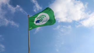 Vihreä lippu liehuu tuulessa.