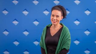 Henkilöstöjohtaja kuvattuna Vantaa-seinän edessä.