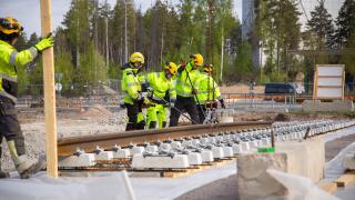 Rakentajat asentavat Vantaan ratikan ensimmäisiä ratakiskoja Muuran alueella.