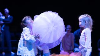 Kulttuurilapsia esityksessä suuren pallon kanssa.