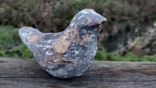 Lasten tekemä pronssilintu Kultainen häkki -teoksesta.