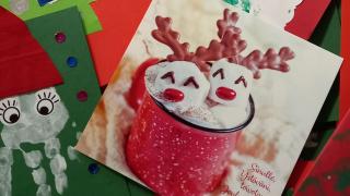 Joulukortteja levitettynä pöydälle.