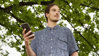 Ihminen pitää puhelinta kädessään.