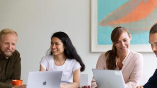 Neljä ihmistä tekevät töitä yhdessä.