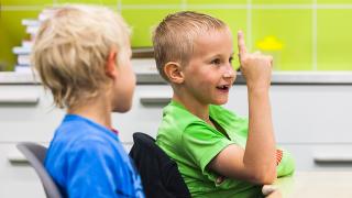 Kaksi koululaista istuu pulpetissa.