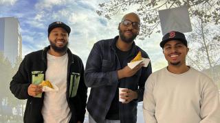 Kuvassa on kolme henkilöä, jotka hymyilevät ja katsovat kameraan.