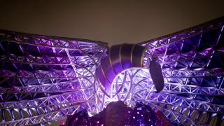 Korppi-veistos sinisessä valaistuksessa.