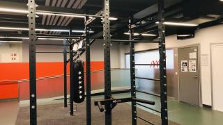 Musta, metallinen kiipeily ja leuanvetoteline, josta roikkuu nyrkkeilysäkki.