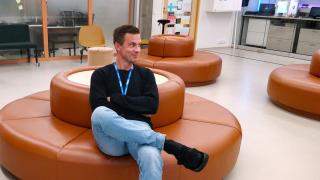 Juuso istuu koulun aulassa sohvalla.