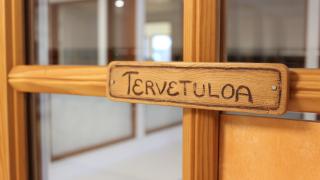 Kuvassa oveen kiinnitetty kyltti, jossa lukee tervetuloa.