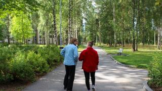 Kaksi ihmistä kävelyllä puistossa. 