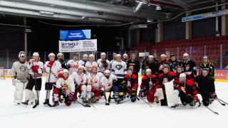 Korttelikiekon voittajajoukkueet jäähallin jäällä yhteiskuvassa pelivarusteet päällä.