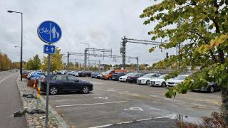 Pysäköintialueella autoja parkissa. 