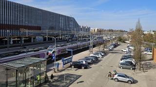 Parkkipaikka junaradan vieressä aurinkoisena päivänä. 