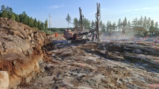 Kuvassa näkyy kalliopintaa Vaaralan varikkoalueella sekä kallionporauslaitteet kalliota poraamassa.