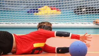 Punapaitainen lapsi maalipallolasit silmillään syöksyy estämään maalipallon kulkua maaliin.