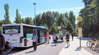 Ihmisiä bussipysäkillä Martinlaaksossa. 