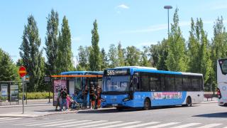 Ihmisiä nousemassa bussiin. 