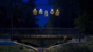 Johanna Ilvessalon Kultainen häkki -taideteos valaistuna Jokiuomanpuistossa ilta-aikaan.