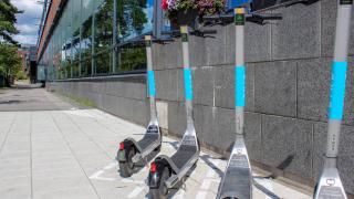 Sähköpotkulautoja pysäköitynä kadulla Martinlaakossa. 