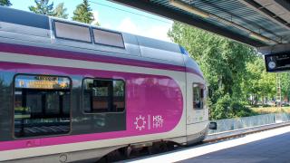 Pinkiksi maalattu juna saapuu Martinlaakson rautatieasemalle. Kyljessä näkyy HSL:n logo.