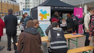 Myyrmäen tapahtumaan osallistuneita ihmisiä pieninä ryhminä juttelemassa ulkona.