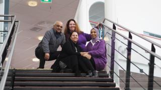 Neuvova Vantaa -hankkeen työntekijät Momeni, Irina, Khalida ja Mariam hymyilevät kameralle Myyrmäkitalon rappusissa.