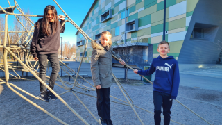 Kanniston koulun oppilaat Diego, Janna ja Lenni kiipesivät kiipeilytelineeseen koulun pihalla.