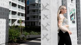 Henkilö kävelee talon edustalla.