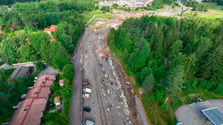 Ilmakuvassa asennuspaikalta vasemmalta päin lähialueen rakennuksia, jalankulun ja pyöräilyn tiet ja tankkausasema.