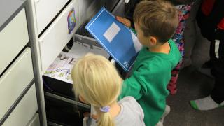 Elever letar efter anteckningsböcker från lådor.