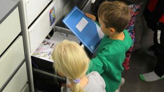 Pupils are taking notebooks from drawers.