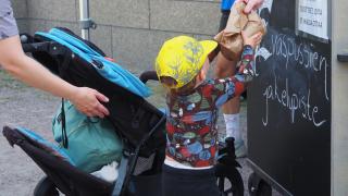 Lapsi ottaa eväspussia kioskilta.