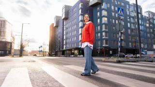 Nainen ylittää tietä.