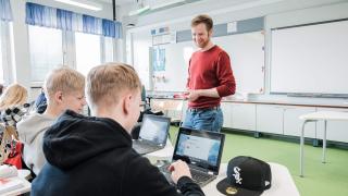 Opettaja ja kaksi oppilasta.