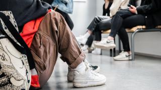 Nuori istuu koulun käytävällä