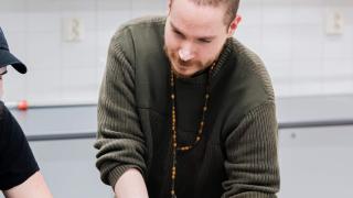 Opettaja auttaa opiskelijaa luokassa