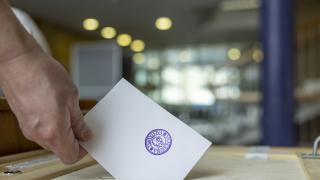 käsi tiputtaa äänestyslipun äänestyslaatikkoon